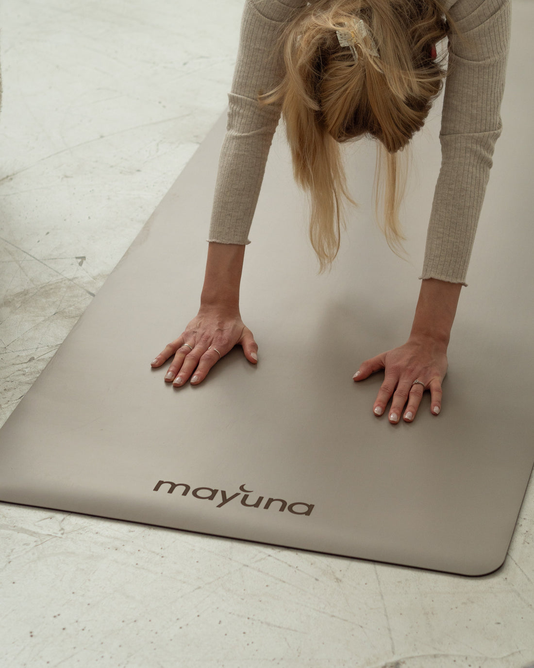 Frau im Vierfüßlerstand auf der Mayuna Yogamatte Lotus, Nahaufnahme von Händen und Mattenoberfläche