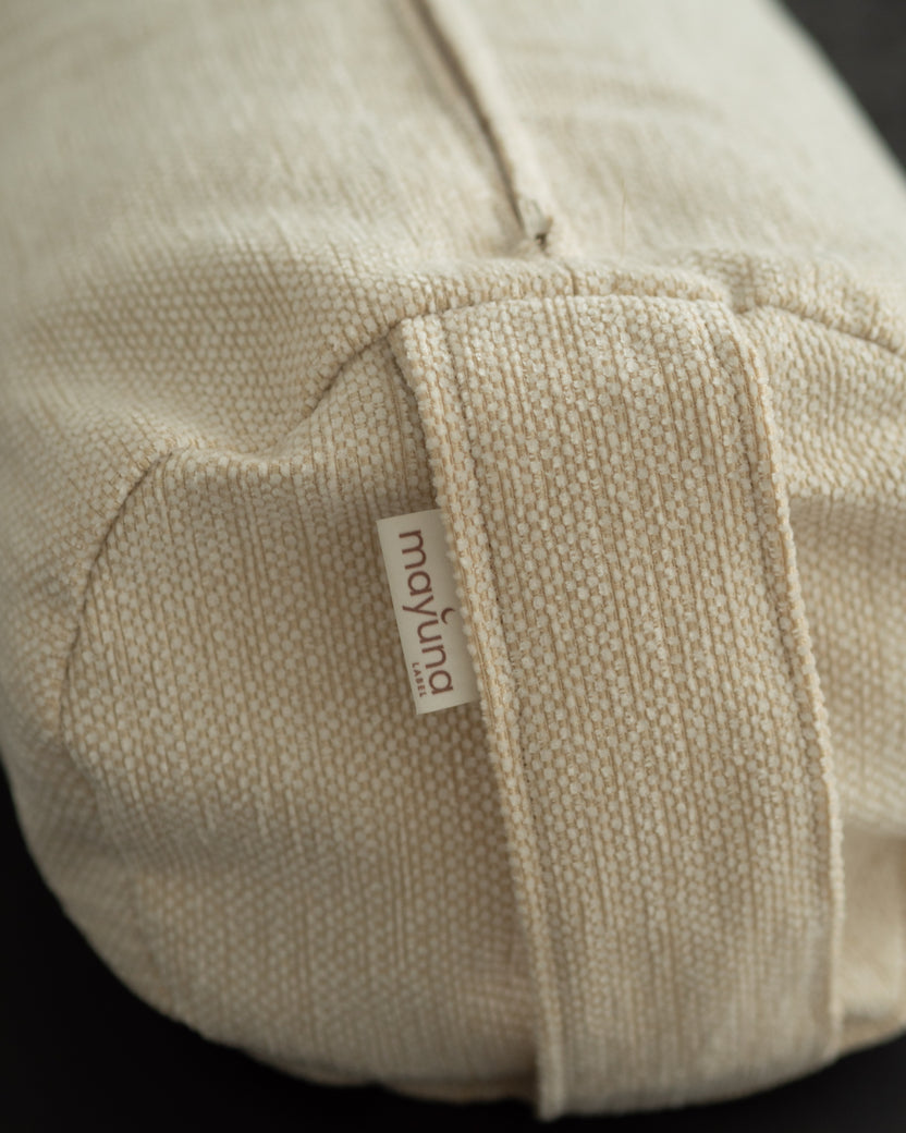 Nahaufnahme der Leinen-Textur und des Tragegriffs des Mayuna Yogabolsters in Sand mit mayuna Label