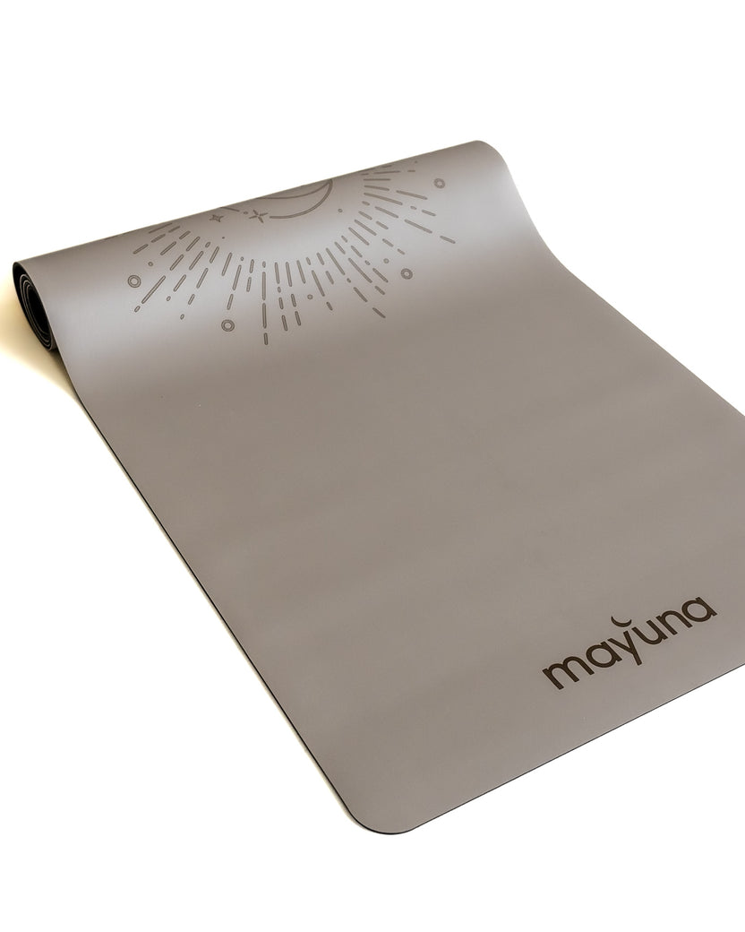 Halb aufgerollte Mayuna Yogamatte Soluna in Taupe von oben, eingravierte Sonnen- und Mond-Grafik sichtbar